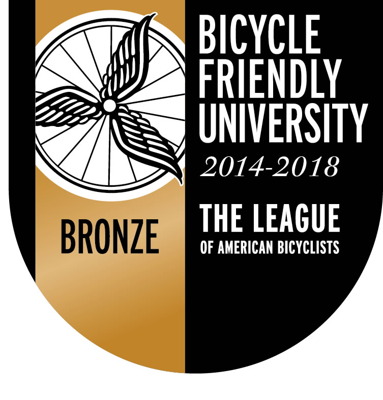 Bike Friendly University logo with a wheel on the left with a bronze background and program language on the right